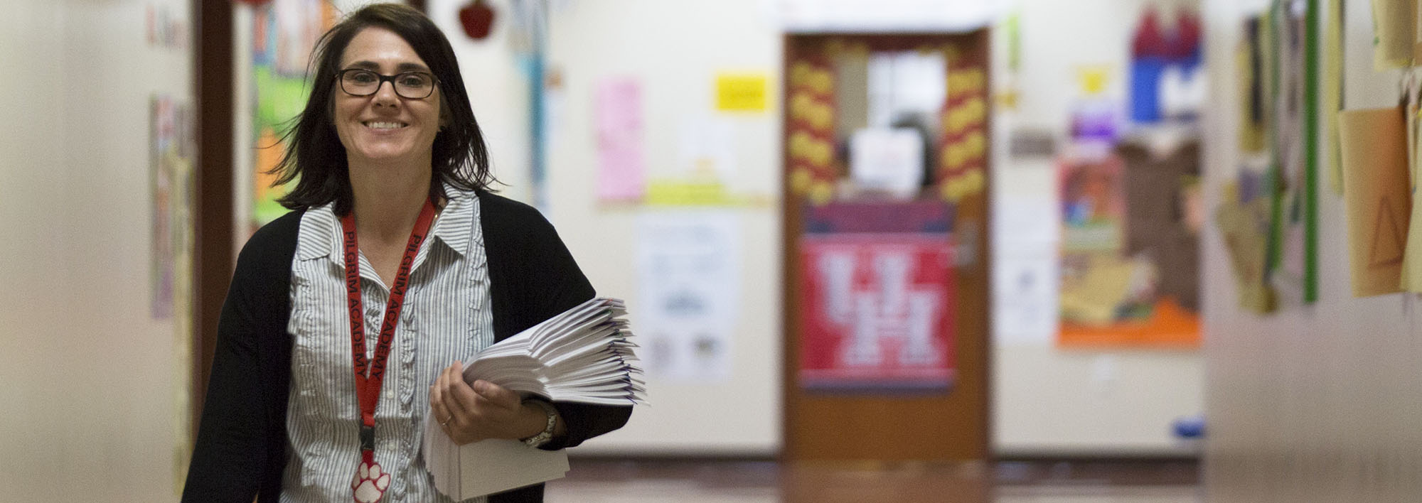 Woman walking through a school hallway