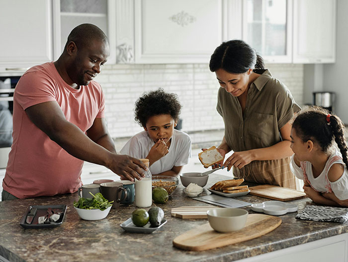 Mom and dad with two kids eating at the kitchen island