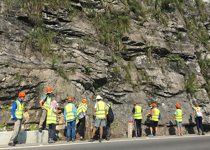 Students examining sedimentary rocks and faults in the Zigui region.