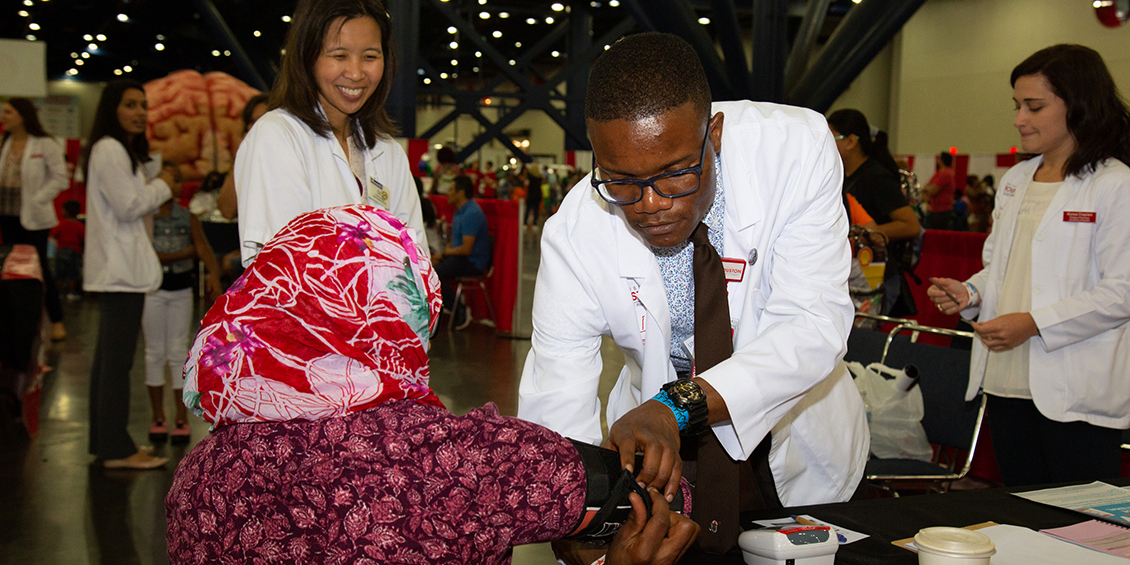 Student measuring patients blood pressure.