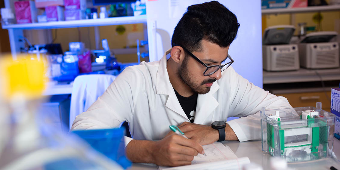 student takes notes during experiment