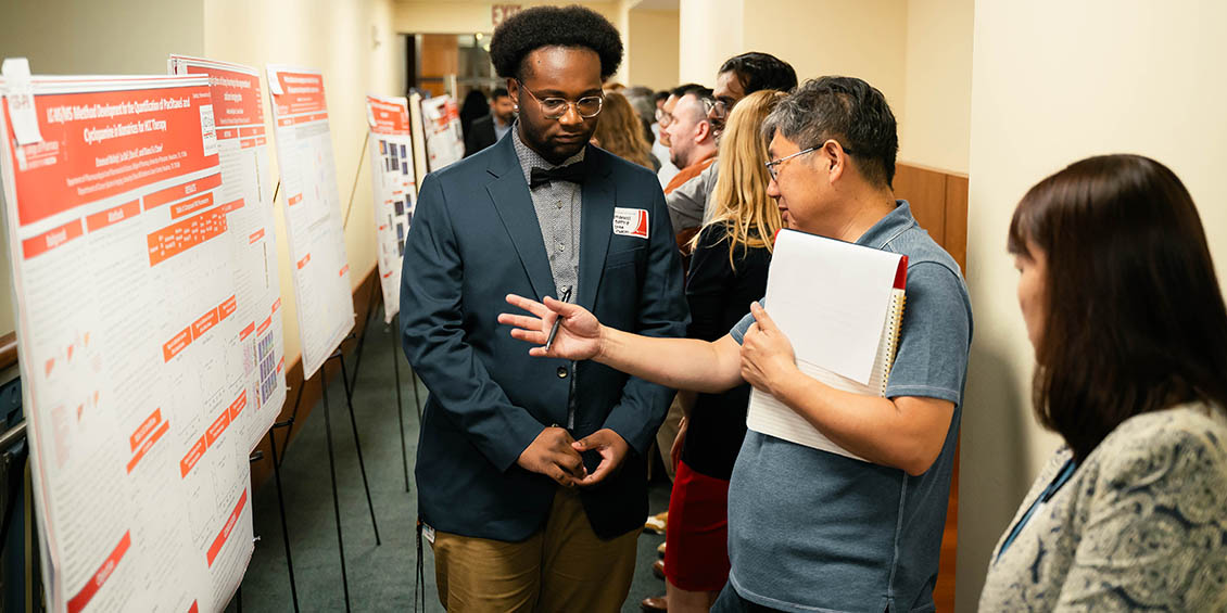 student discussing research poster