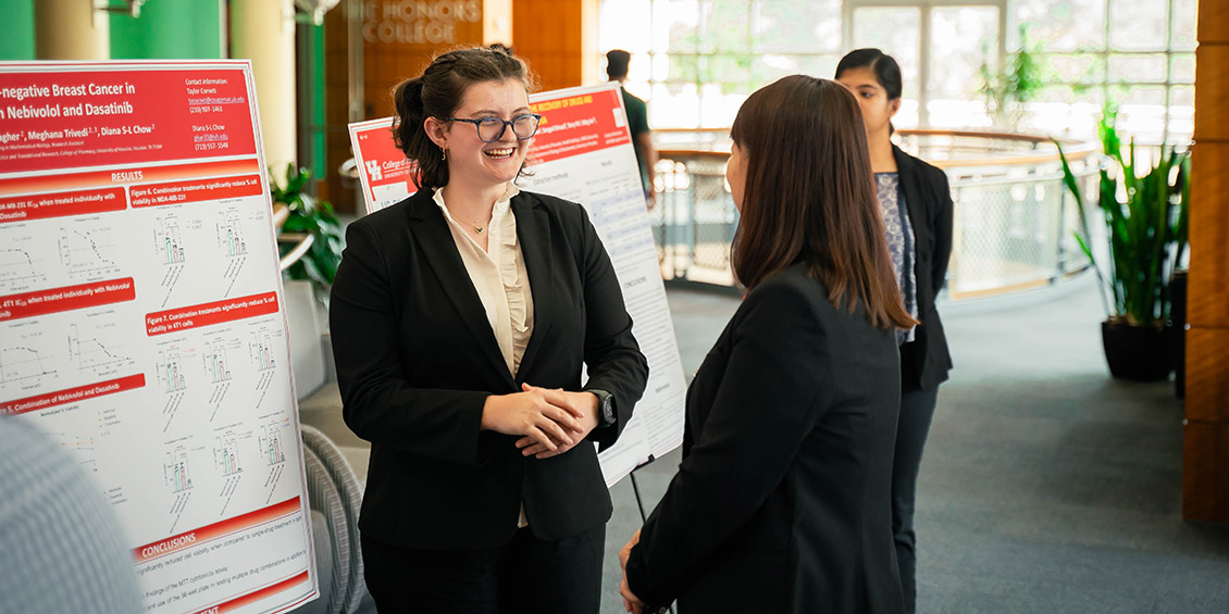 Presenter showing poster to attendees